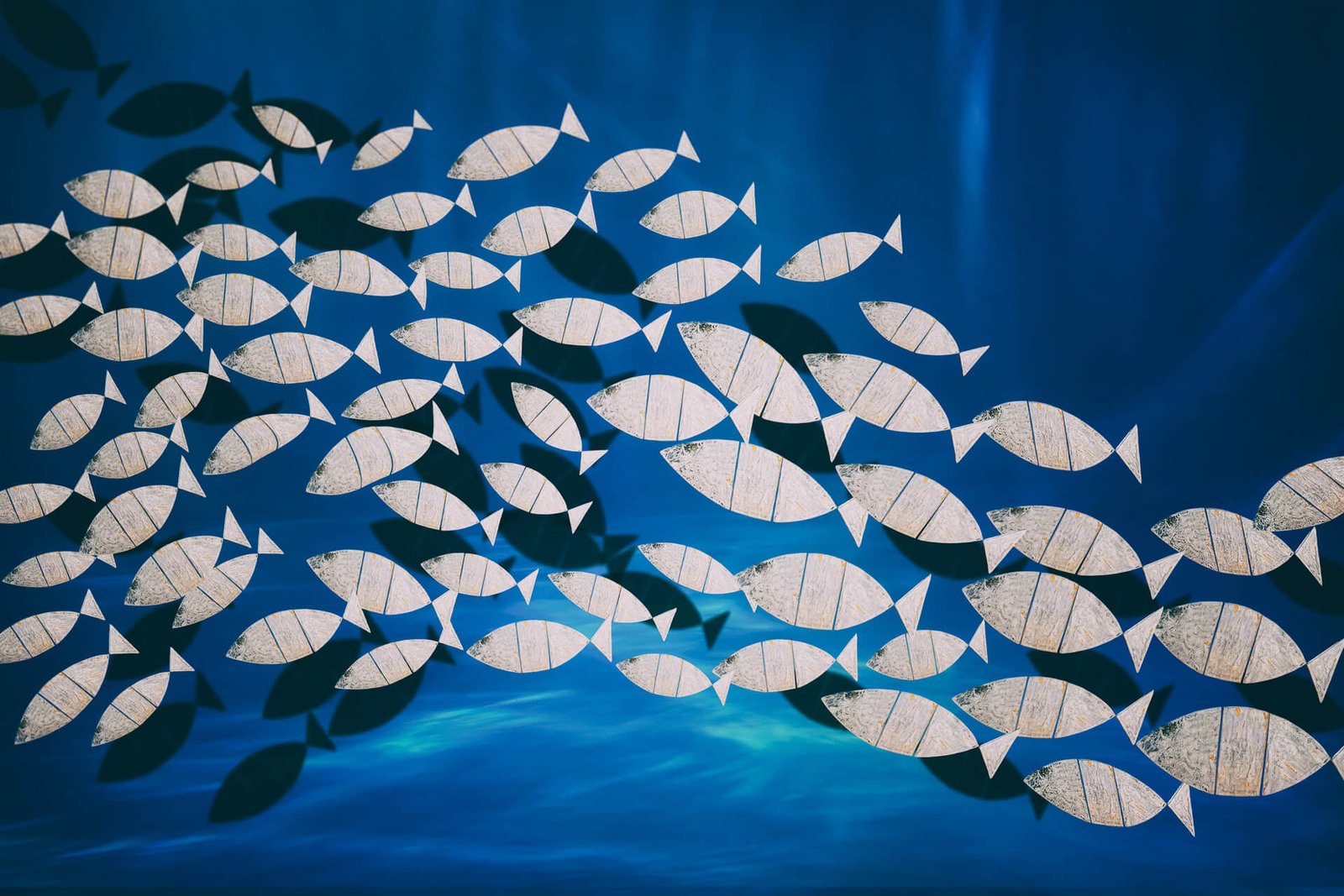 Ławica - fotografika Dziesiątki uproszczonych graficznie ryb, poruszają się w jednym kierunku