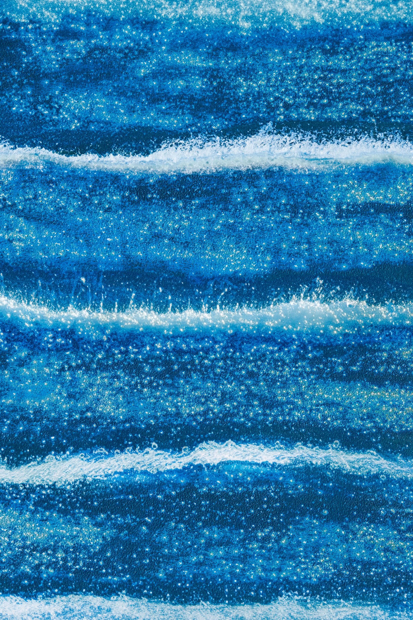 Ostsee - fotografika Poziome pasy w różnych odcieniach błękitu, które przywodzą na myśl kolejne fale nadciągające na brzeg.